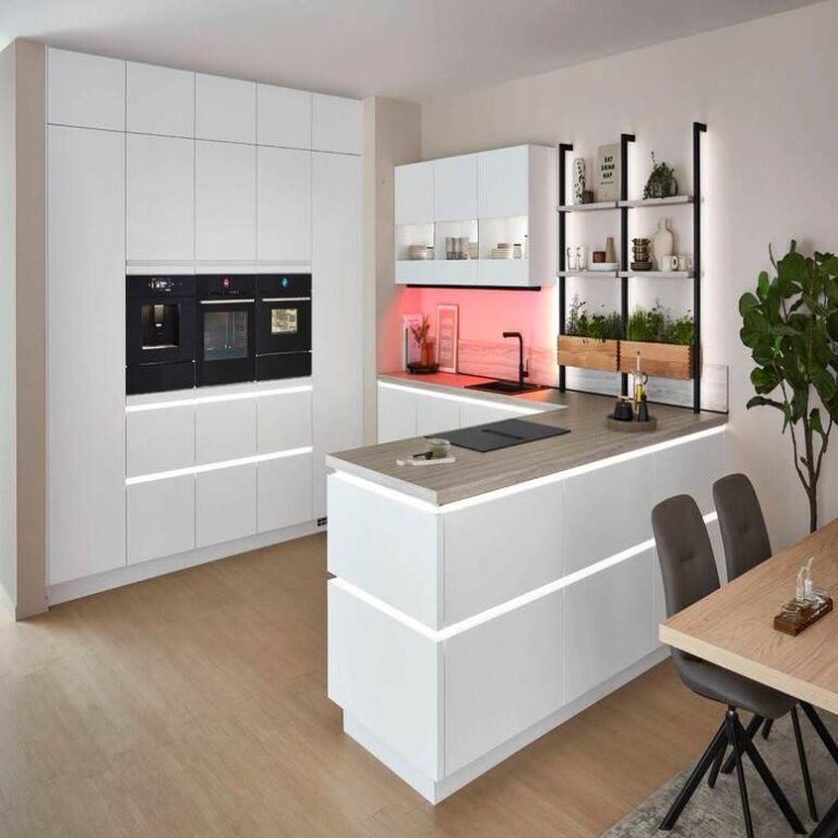 Weiße Küche mit beleuchteter Insel Moderne grifflose Küche in Weiß mit beleuchteter Kochinsel und Kräuterregal – Küchenstudio Saarbrücken