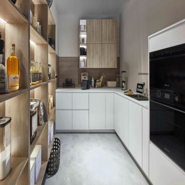 Moderne weiße Küche – Küchenstudio Saarbrücken Moderne weiße Küche mit Hochschränken, Holzregal und schwarzen Einbaugeräten